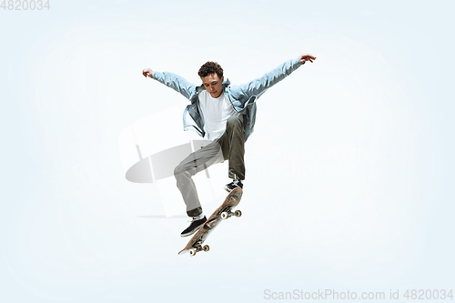 Image of Caucasian young skateboarder riding isolated on a white background