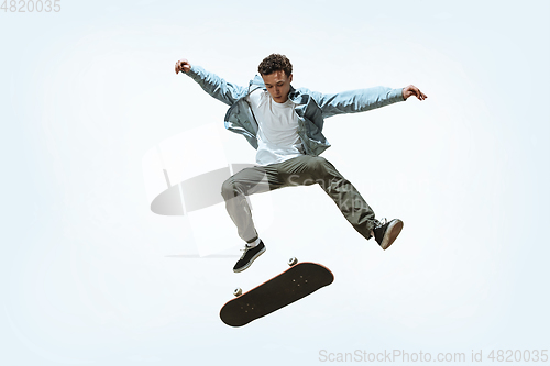Image of Caucasian young skateboarder riding isolated on a white background
