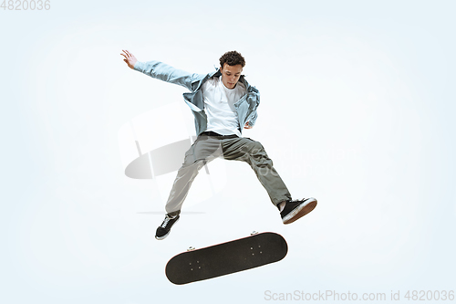 Image of Caucasian young skateboarder riding isolated on a white background