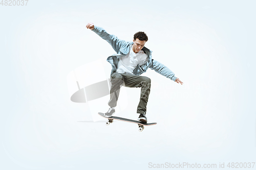 Image of Caucasian young skateboarder riding isolated on a white background