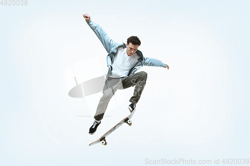 Image of Caucasian young skateboarder riding isolated on a white background