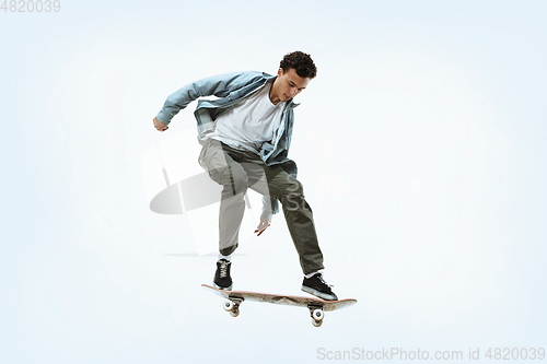 Image of Caucasian young skateboarder riding isolated on a white background