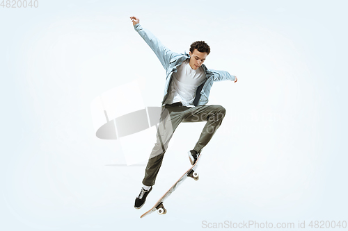 Image of Caucasian young skateboarder riding isolated on a white background