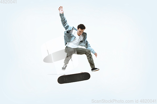 Image of Caucasian young skateboarder riding isolated on a white background