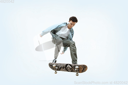 Image of Caucasian young skateboarder riding isolated on a white background