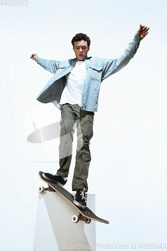 Image of Caucasian young skateboarder riding isolated on a white background