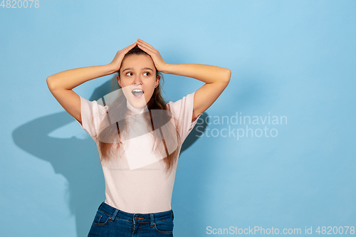 Image of Caucasian teen girl portrait isolated on blue studio background