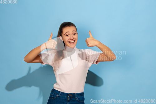 Image of Caucasian teen girl portrait isolated on blue studio background