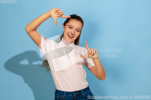 Image of Caucasian teen girl portrait isolated on blue studio background