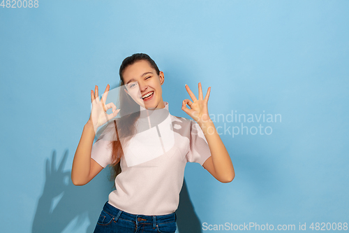 Image of Caucasian teen girl portrait isolated on blue studio background