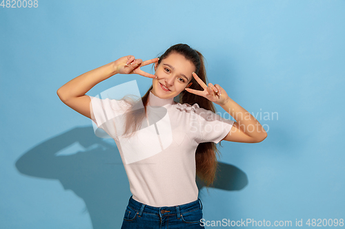 Image of Caucasian teen girl portrait isolated on blue studio background