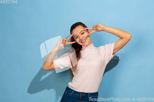 Image of Caucasian teen girl portrait isolated on blue studio background