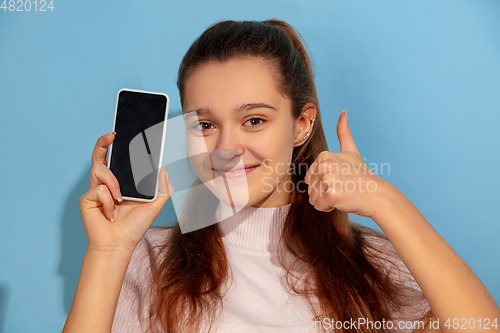 Image of Caucasian teen girl portrait isolated on blue studio background