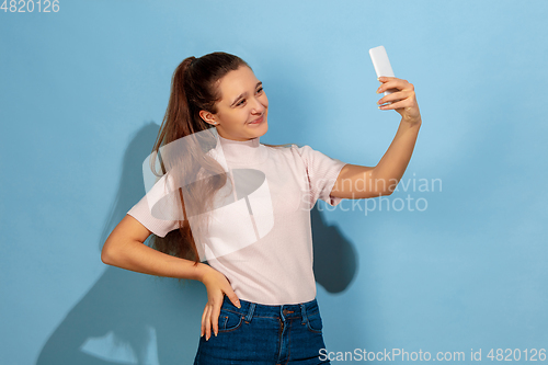 Image of Caucasian teen girl portrait isolated on blue studio background