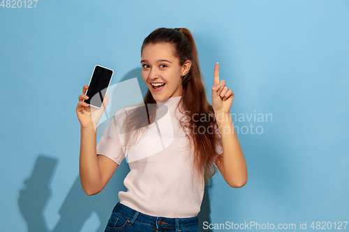 Image of Caucasian teen girl portrait isolated on blue studio background