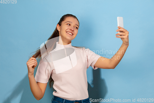 Image of Caucasian teen girl portrait isolated on blue studio background