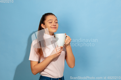 Image of Caucasian teen girl portrait isolated on blue studio background