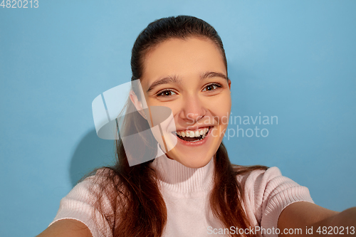 Image of Caucasian teen girl portrait isolated on blue studio background