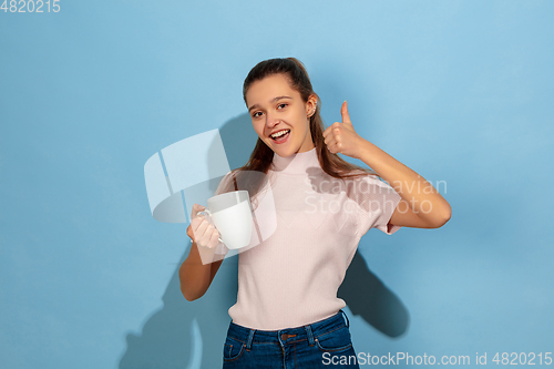 Image of Caucasian teen girl portrait isolated on blue studio background