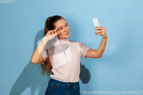 Image of Caucasian teen girl portrait isolated on blue studio background