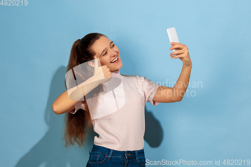 Image of Caucasian teen girl portrait isolated on blue studio background