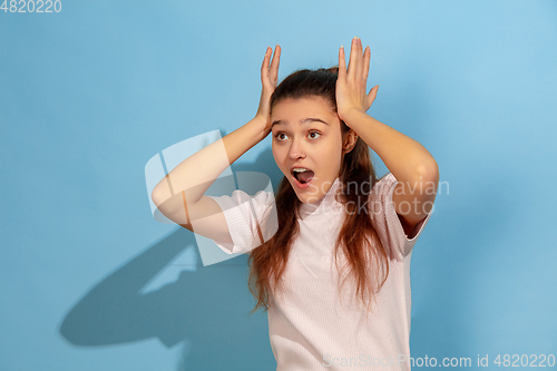 Image of Caucasian teen girl portrait isolated on blue studio background