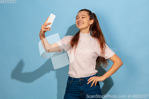 Image of Caucasian teen girl portrait isolated on blue studio background