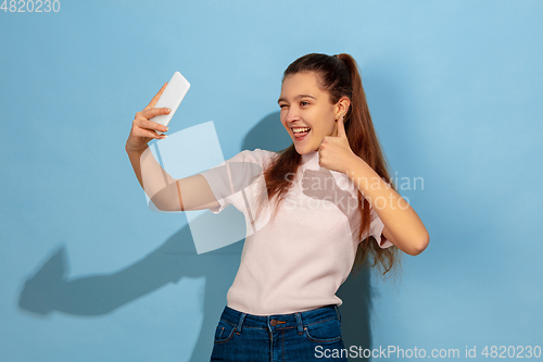 Image of Caucasian teen girl portrait isolated on blue studio background