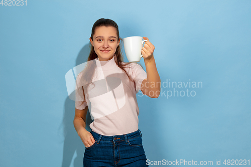 Image of Caucasian teen girl portrait isolated on blue studio background