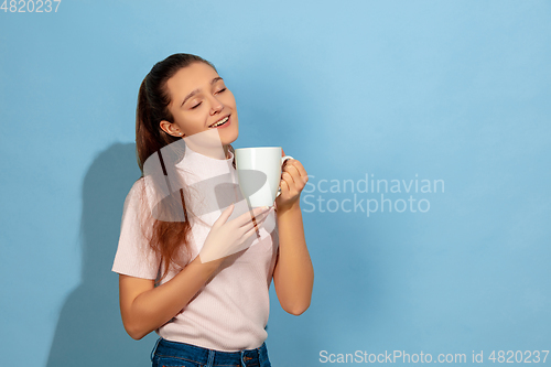 Image of Caucasian teen girl portrait isolated on blue studio background