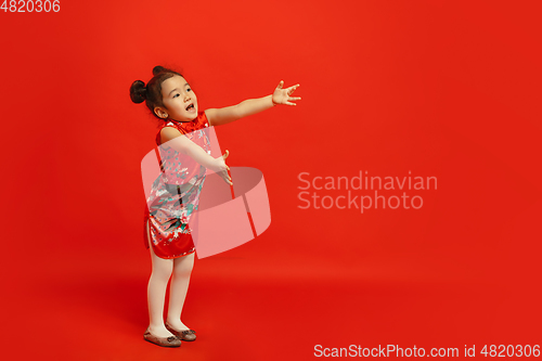 Image of Happy Chinese New Year. Asian little girl portrait isolated on red background