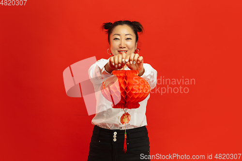 Image of Happy Chinese New Year. Asian young woman portrait isolated on red background