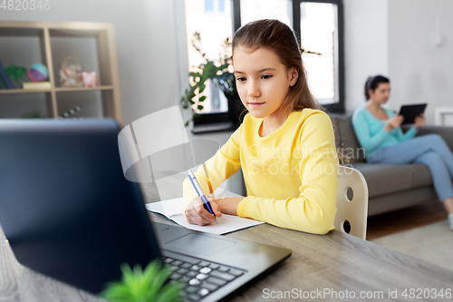 Image of student girl with laptop learning online at home