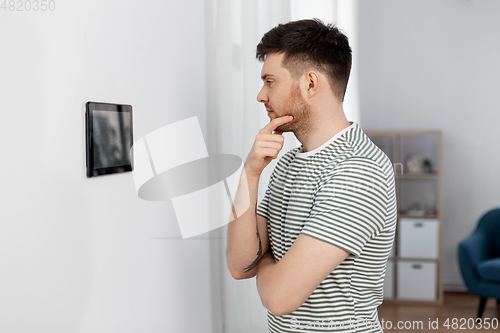 Image of man looking at tablet computer at smart home