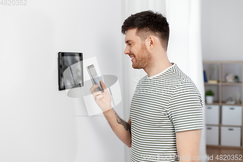 Image of smiling man using tablet computer at smart home