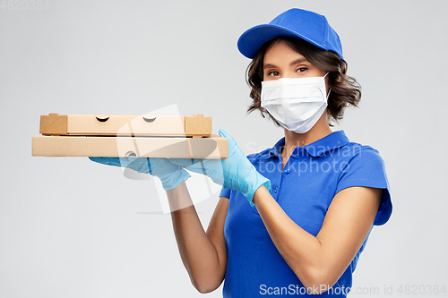 Image of delivery woman in face mask with pizza boxes