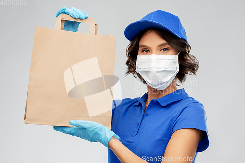 Image of delivery woman in face mask with food in paper bag