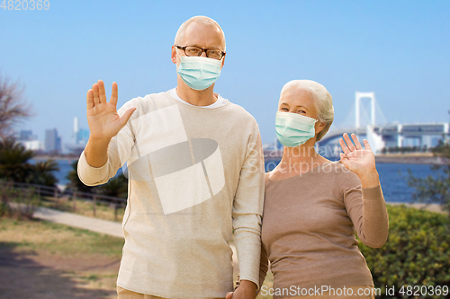 Image of senior couple in protective medical masks in japan