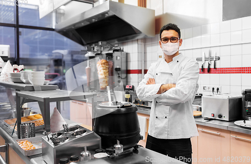 Image of male chef with in face mask at kebab shop kitchen