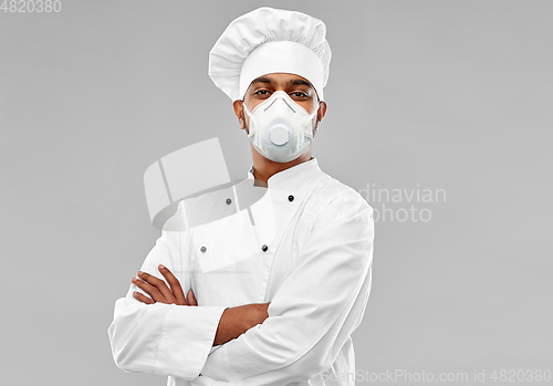 Image of male chef in respirator at restaurant kitchen