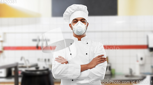 Image of male chef in respirator at restaurant kitchen