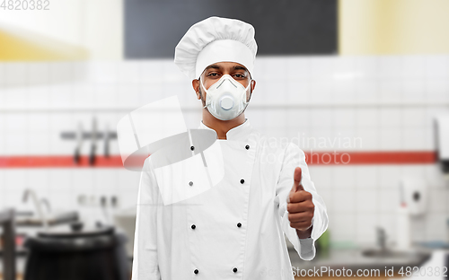 Image of chef in respirator showing thumbs up at kitchen