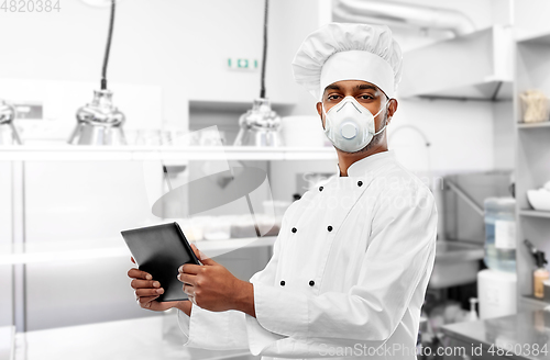 Image of chef in respirator with tablet pc at kitchen