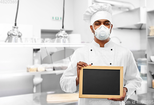 Image of chef in respirator with chalkboard at kitchen