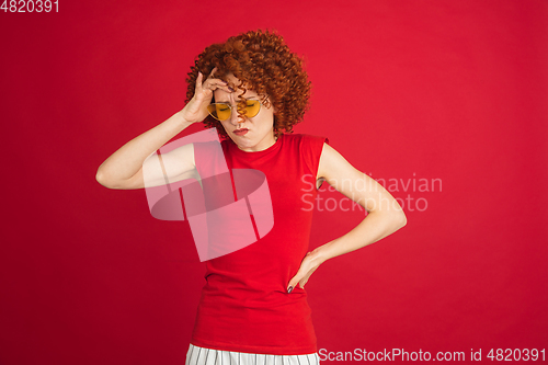 Image of Caucasian woman\'s portrait isolated over red studio background with copyspace