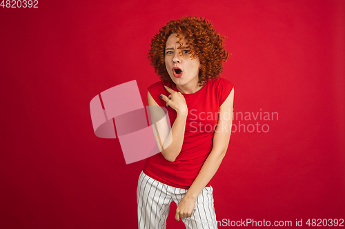 Image of Caucasian woman\'s portrait isolated over red studio background with copyspace