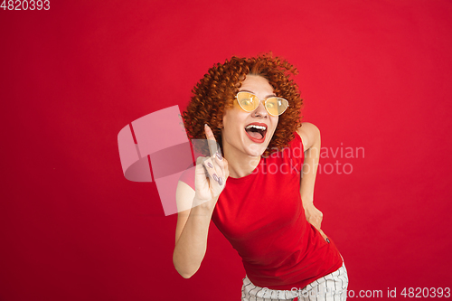 Image of Caucasian woman\'s portrait isolated over red studio background with copyspace
