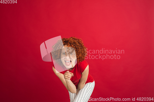 Image of Caucasian woman\'s portrait isolated over red studio background with copyspace