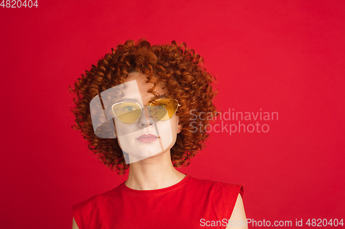 Image of Caucasian woman\'s portrait isolated over red studio background with copyspace