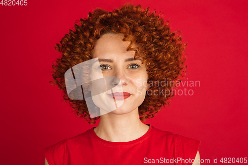 Image of Caucasian woman\'s portrait isolated over red studio background with copyspace